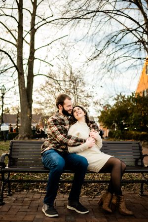 A cozy autumn scene on a park bench surrounded by bare trees.