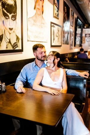 Casual engagement photo series inside restaurant with vintage decor and wooden tables.