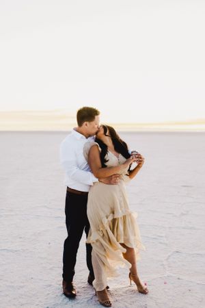 Couple dancing together on white salt flats during a romantic photoshoot.