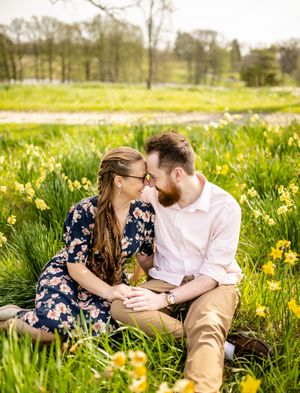 Romantic couple sharing tender moments in a spring field of blooming daffodils.