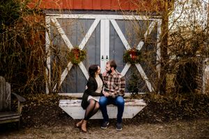 Rustic outdoor photo series with couple posing against weathered barn backdrop.