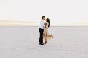 Couple shares intimate dance moves on bright white salt flats.