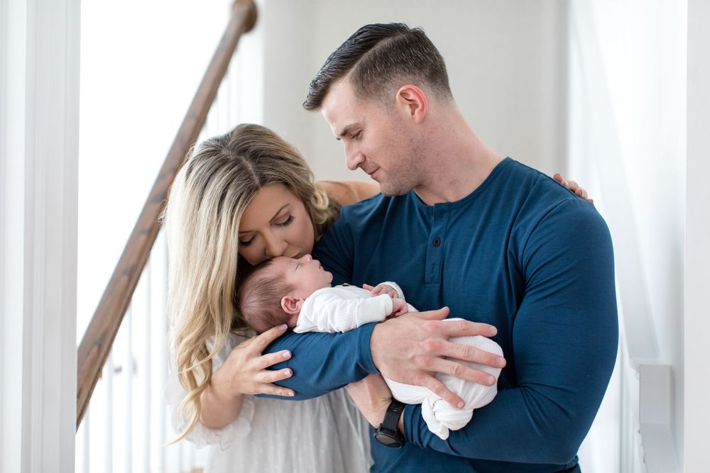 Family moment with newborn baby in bright interior setting.