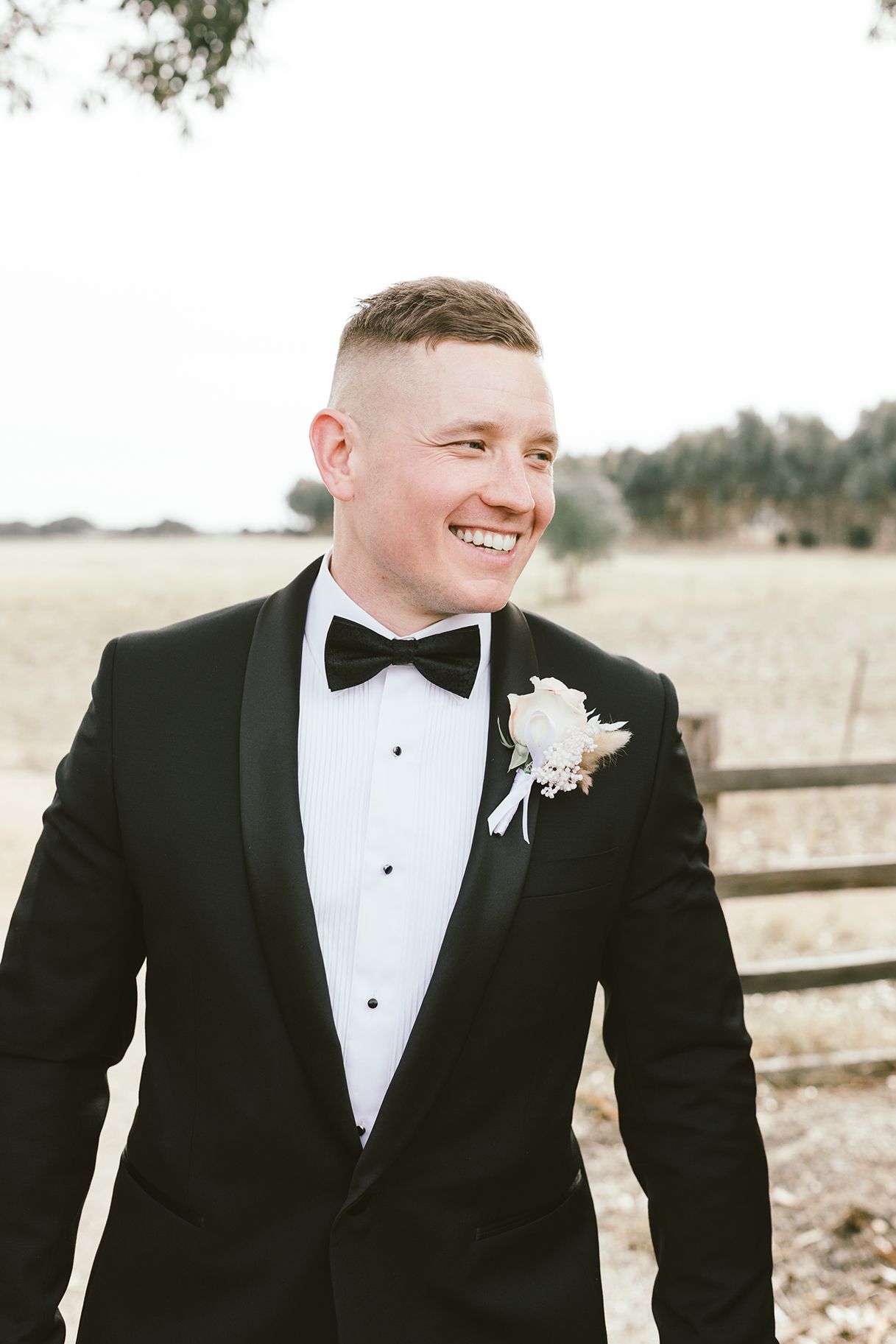 Close-up of groom and groomsmen wearing classic black tuxedos with bow ties.