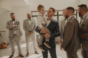 Celebration and laughter among wedding party members in modern indoor setting.