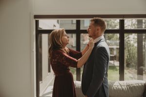 A couple shares an intimate moment while getting ready for their wedding day.