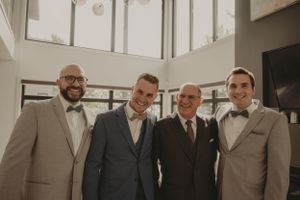 Wedding party members pose together in modern venue with natural lighting.