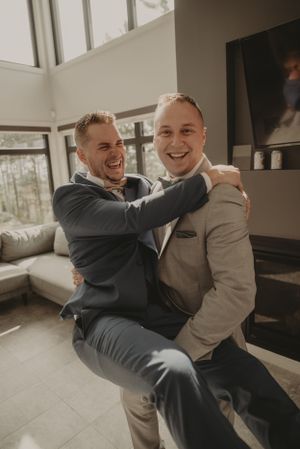 Cheerful wedding day moment captured in modern living room setting.