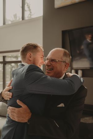 Warm embrace between loved ones during wedding day preparations.