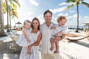 Family portraits on a sunny beach with palm trees and blue skies.