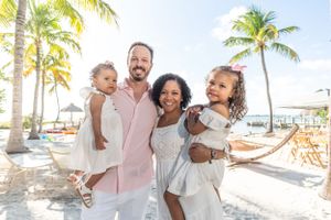 Group photos on a tropical beach with palm trees and clear blue skies.