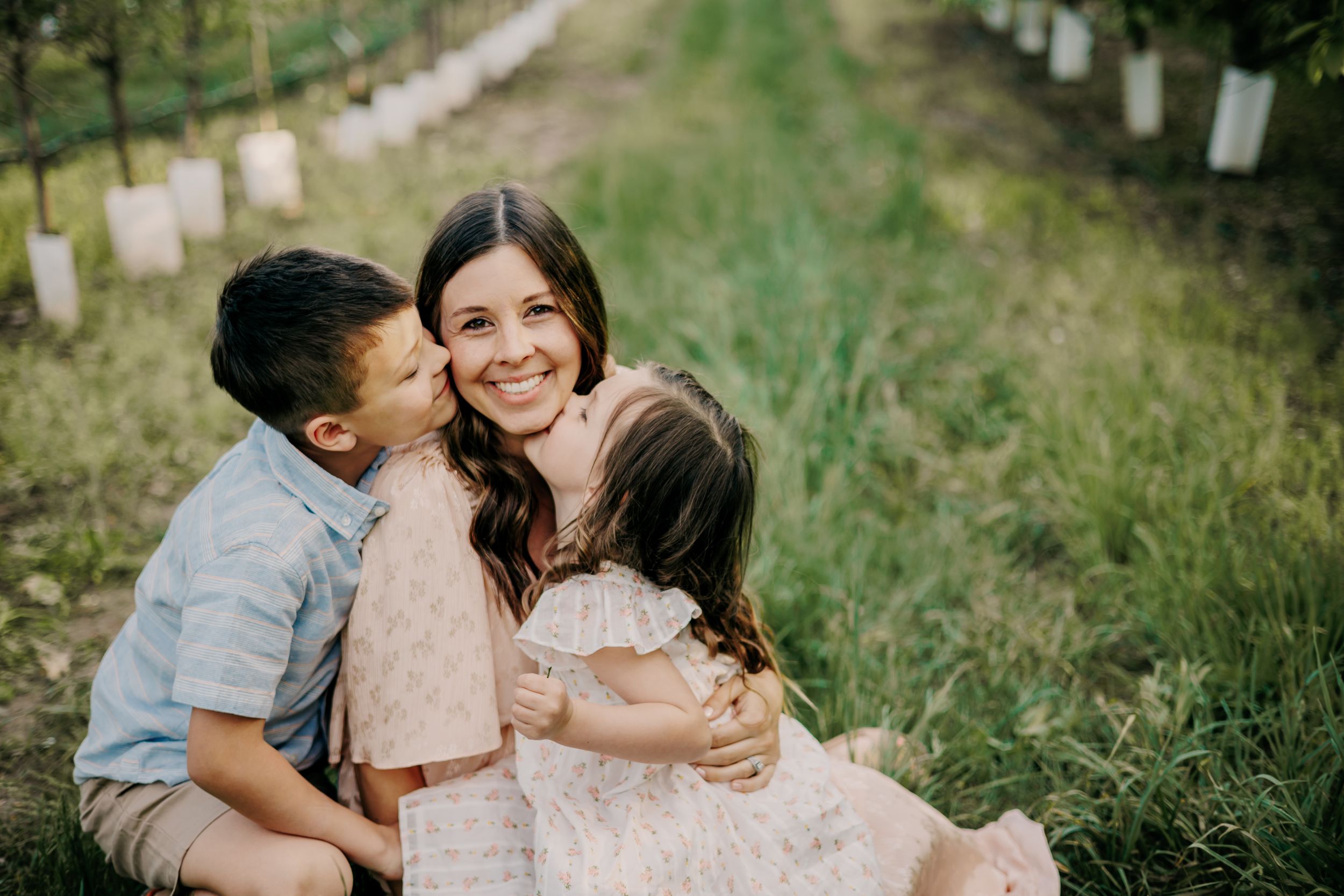 Family sharing joyful embrace together in sunny outdoor setting.