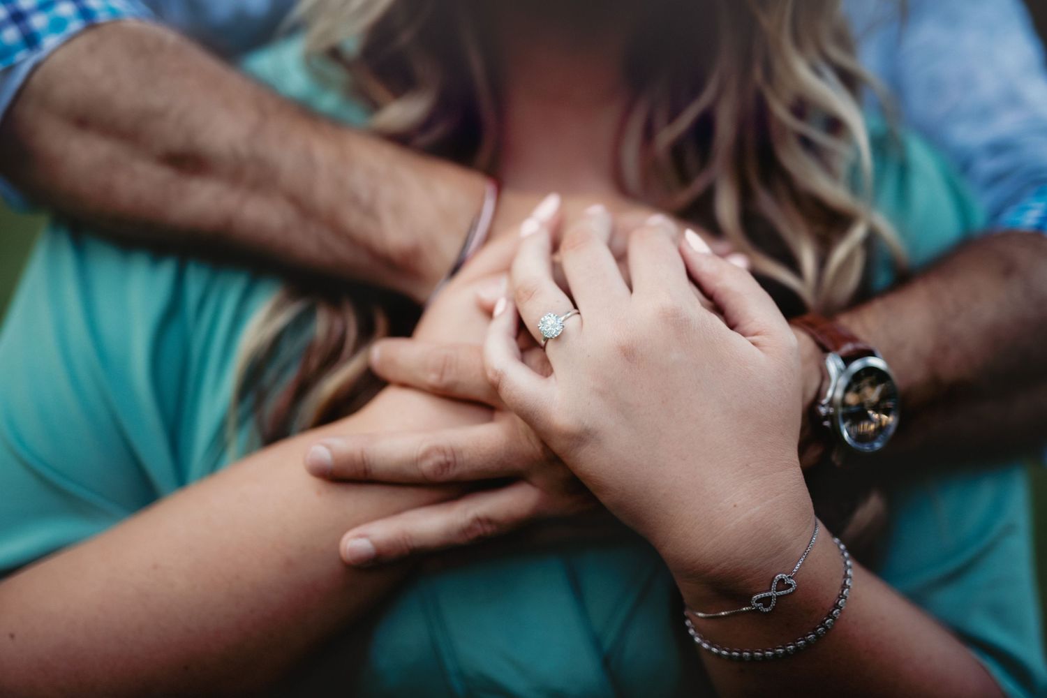 Close up view of hands holding each other.