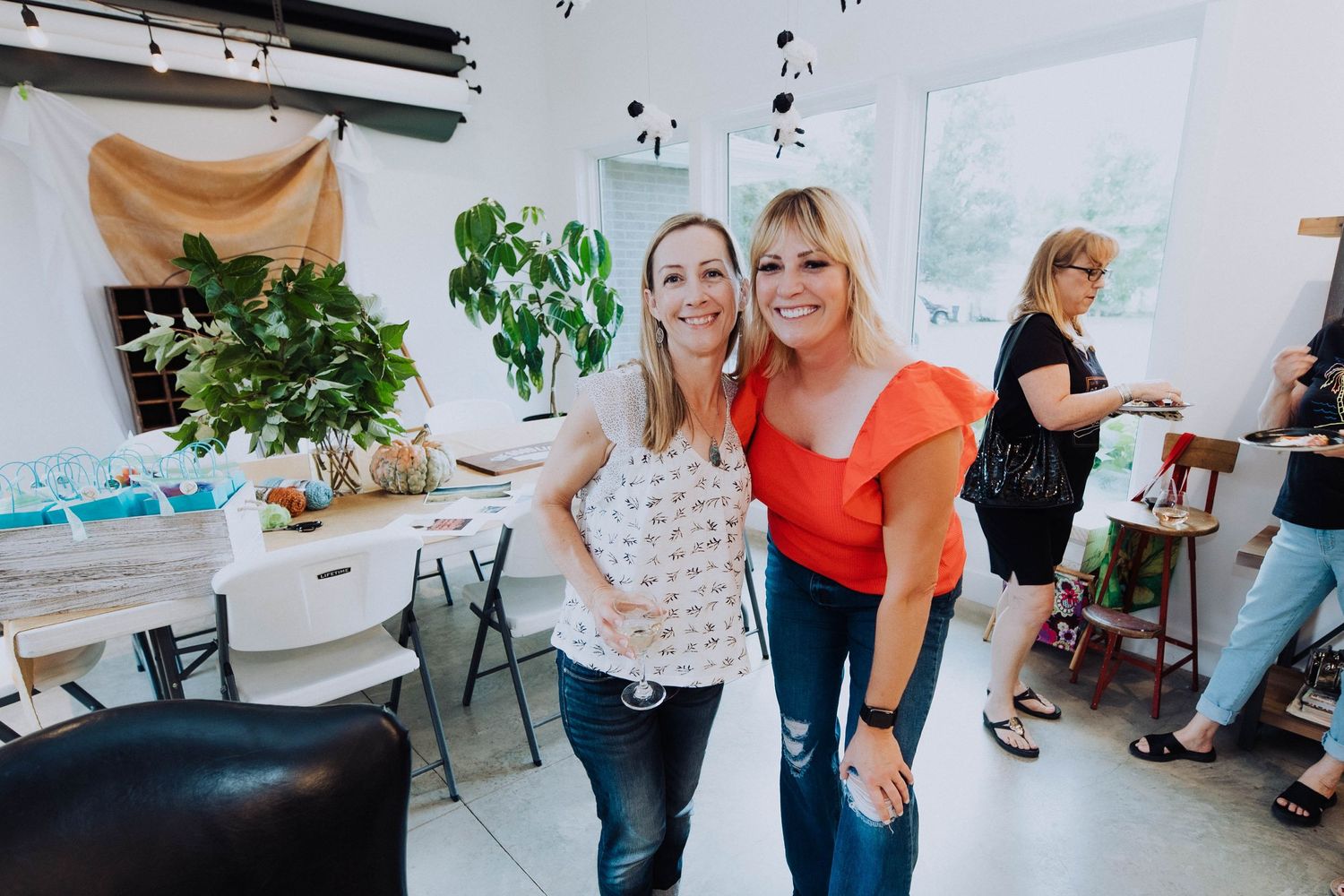 Workshop attendees collaborating in a bright modern space with plants and white walls.