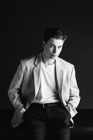 Classic black and white portrait of a person wearing a light blazer and white t-shirt.