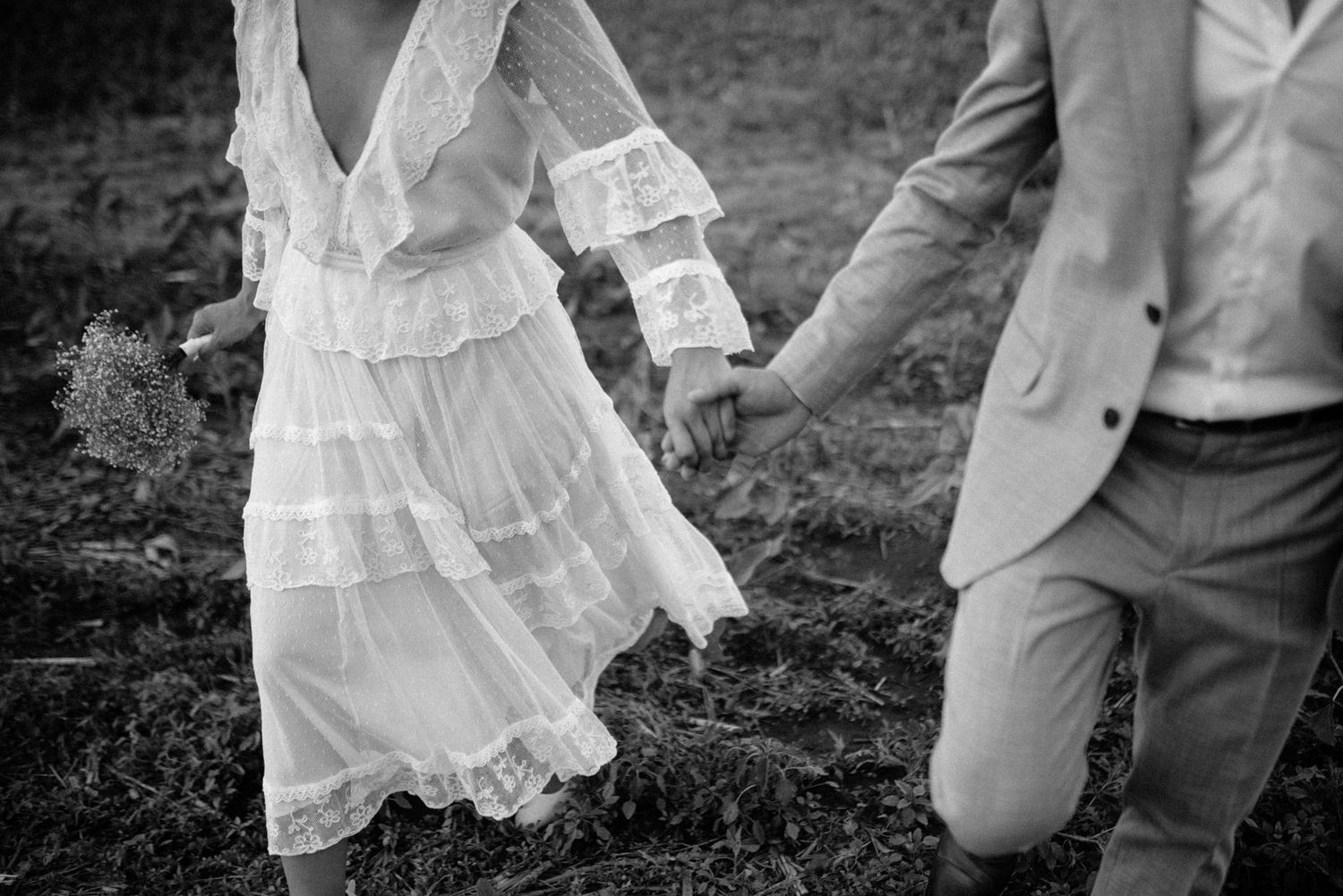 A couple on their wedding day holding hands and walking on a soy field in San Luis Argentina