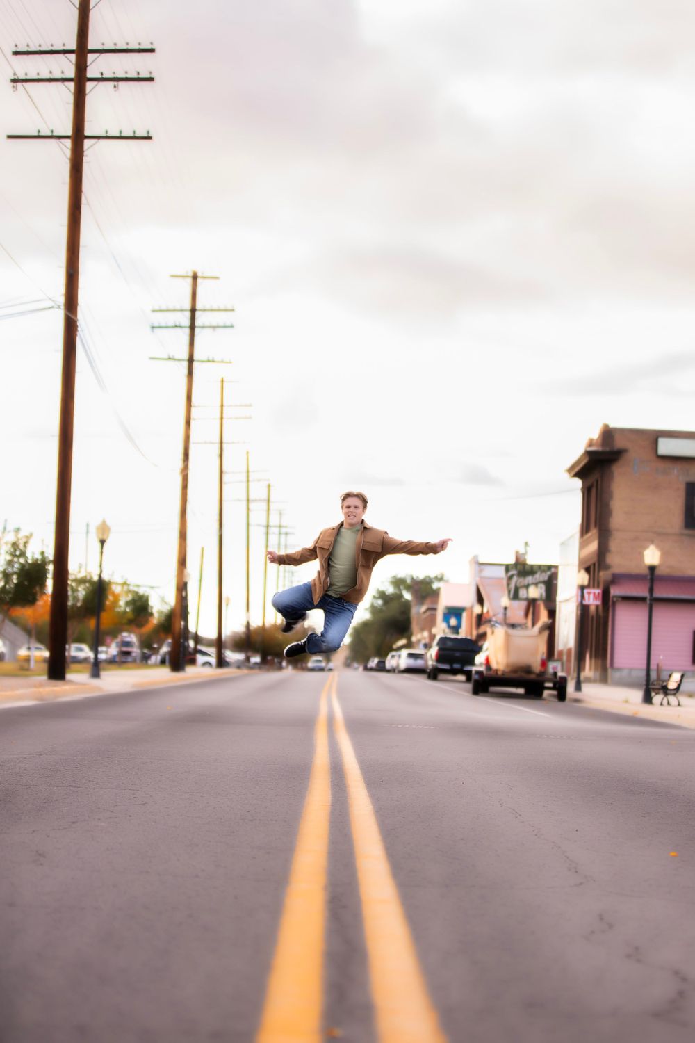 Person leaping dramatically over double yellow lines on empty urban street.