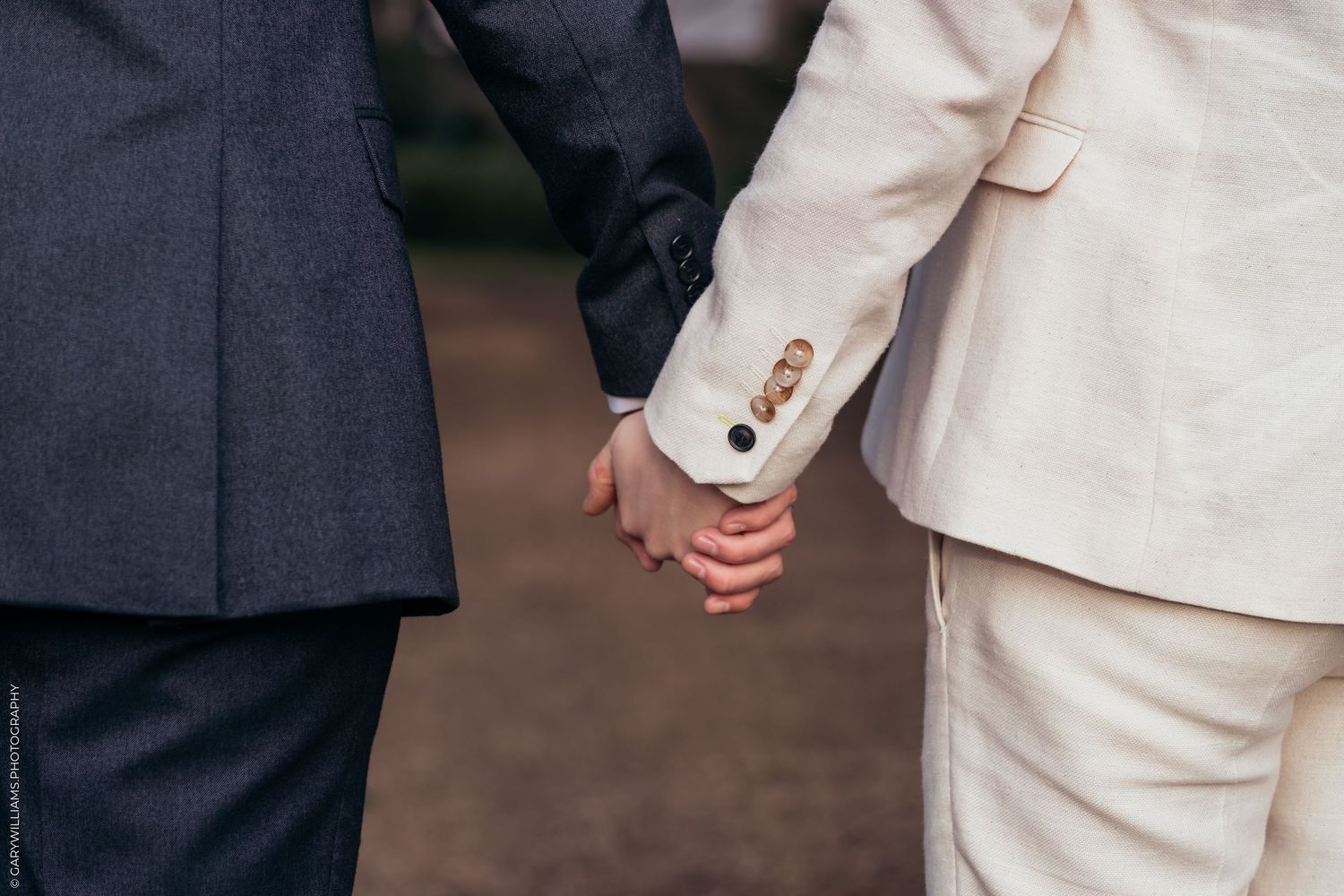 Close up on newlywed grooms holding hands at their gay wedding in Twickenham London