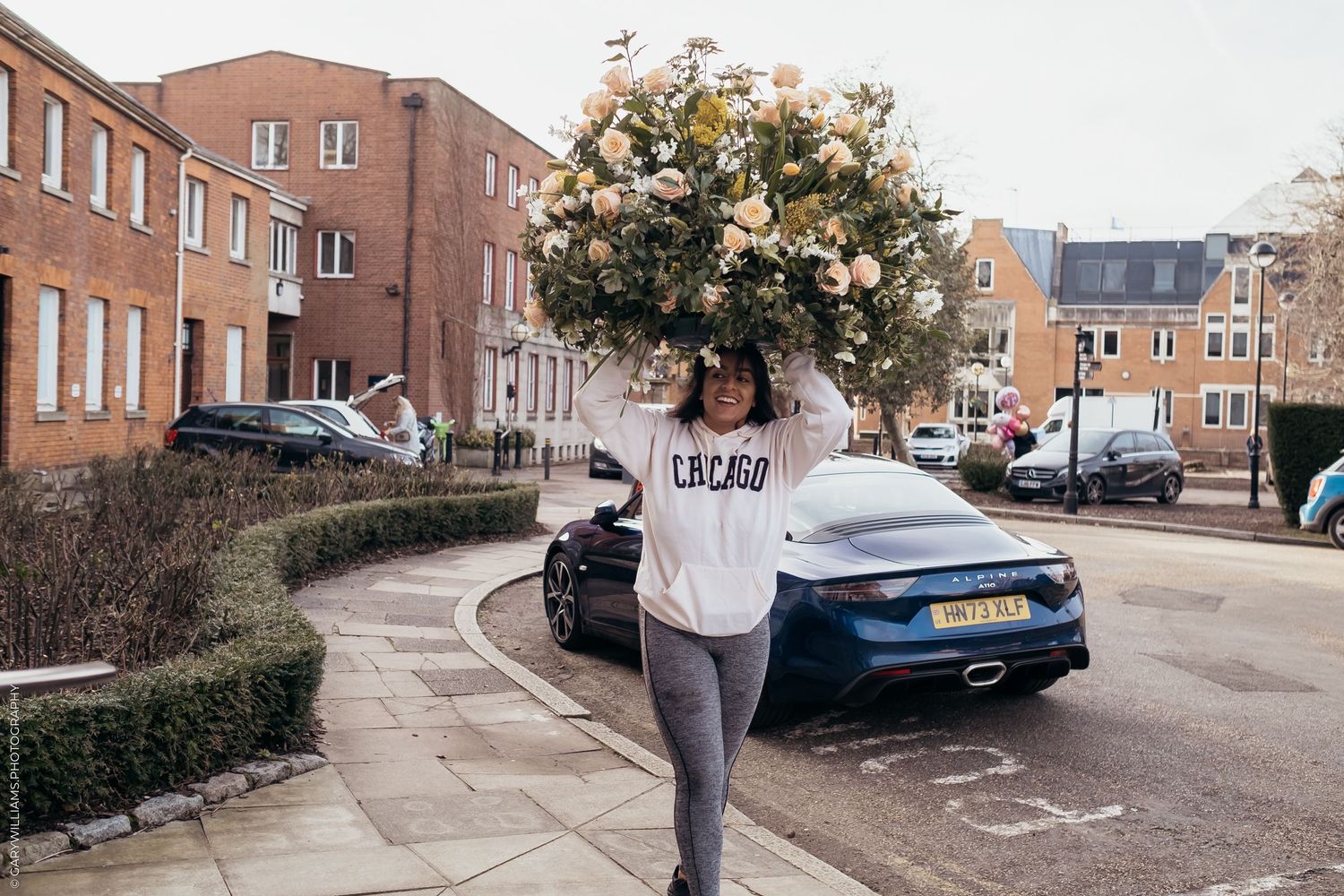 Woman bringing in the flowers to the venue of a gay wedding reception in Twickenham London