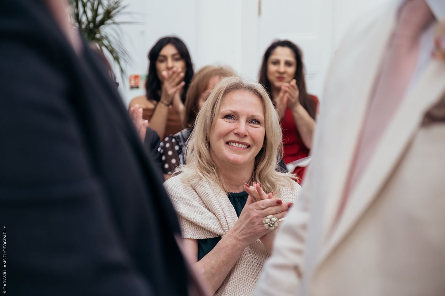 Woman looking on at the newlywed grooms at a gay wedding in Twickenham London