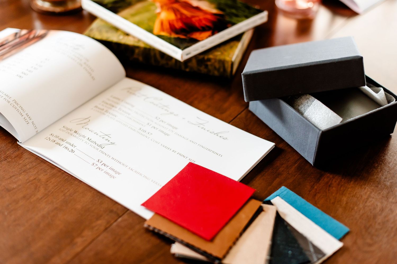 Open planner book with notes and small black box on wooden table.