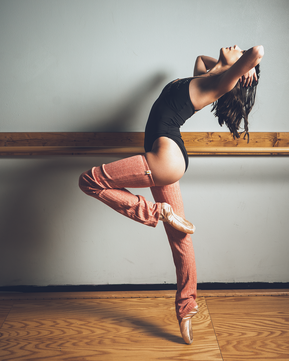 Dancer on-pointe doing a passe, cambre back while running her hands through her hair, photo by Brian Balloon Media