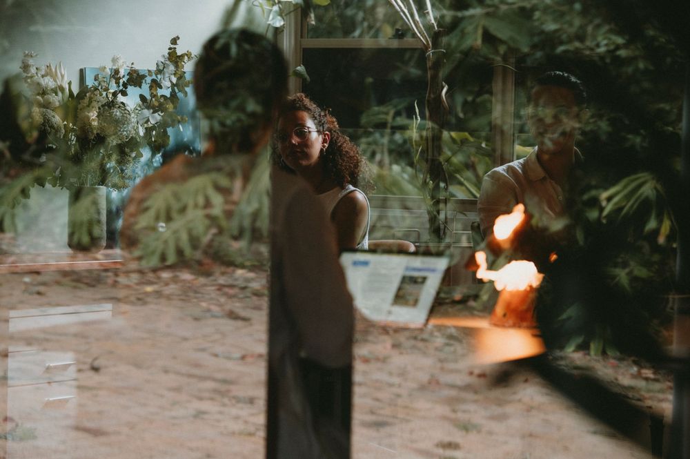 Person holding a burning sparkler or flame outdoors at dusk.