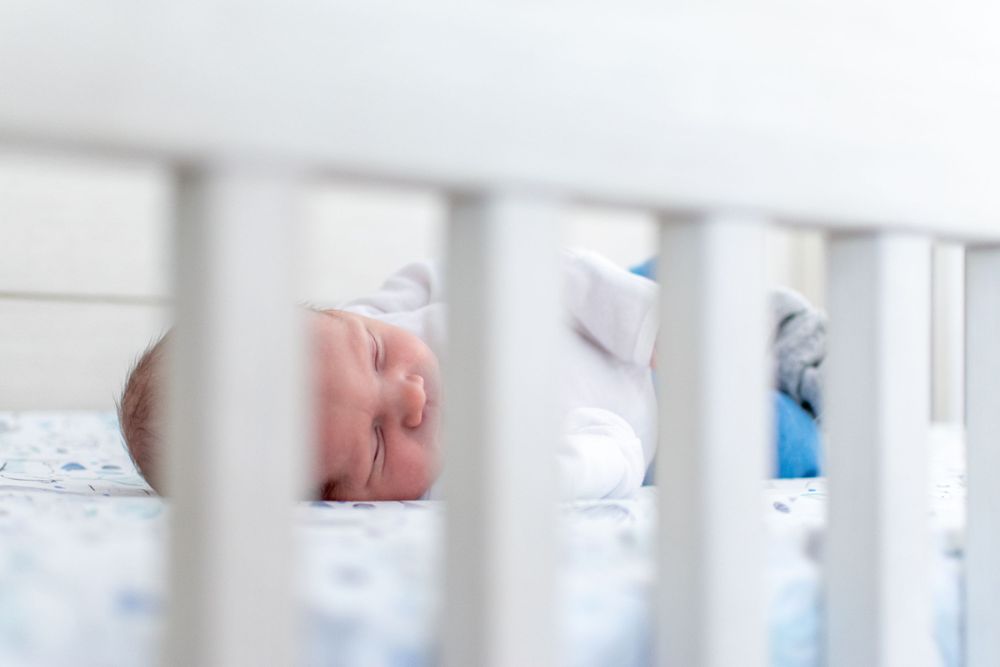 View through white crib slats of peaceful naptime scene.