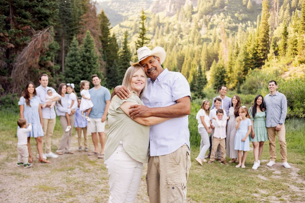 happy couple hugging with children and grandchildren surrounding them