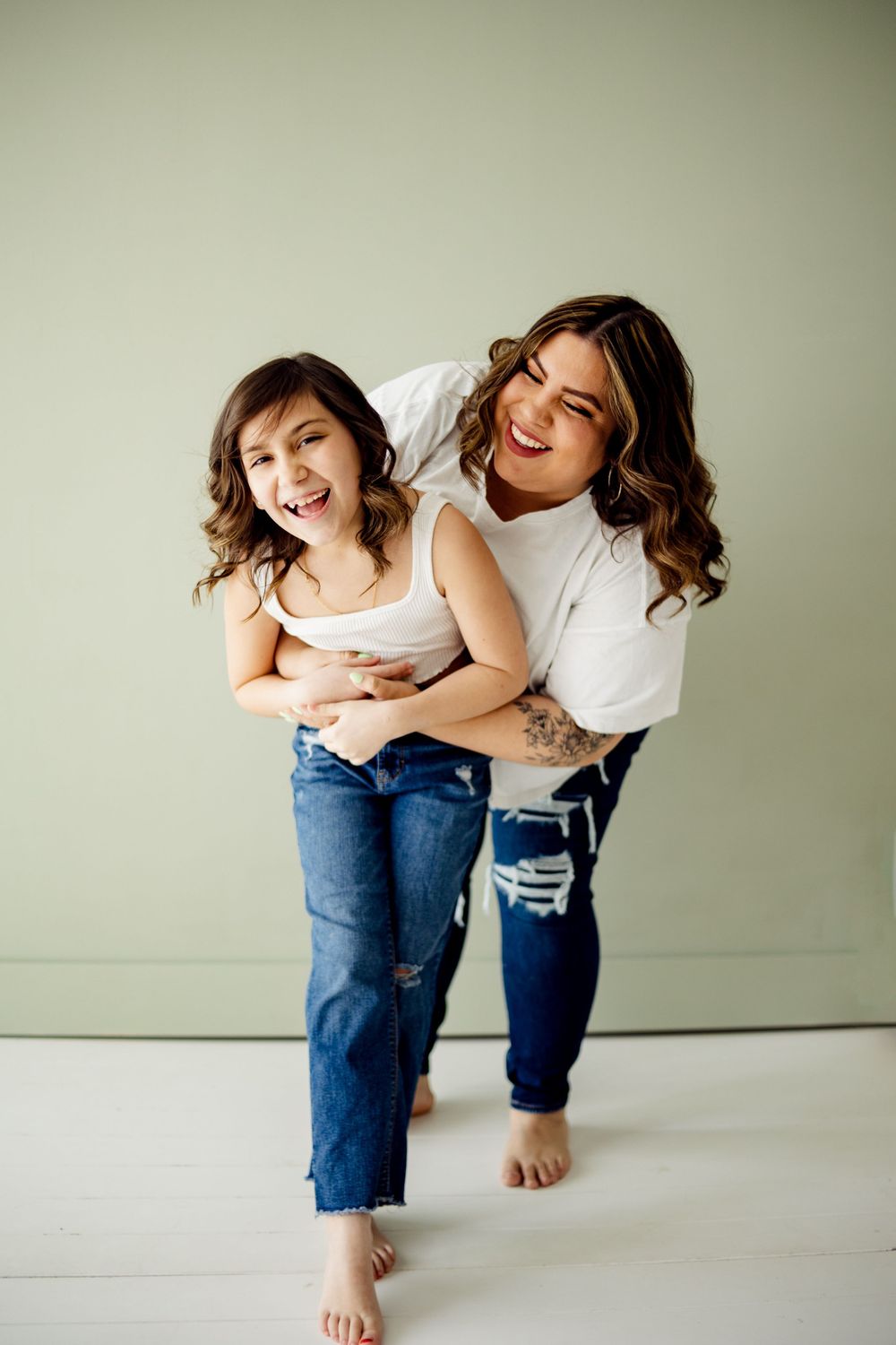 fun and playful mom hugs daughter in missouri photo studio