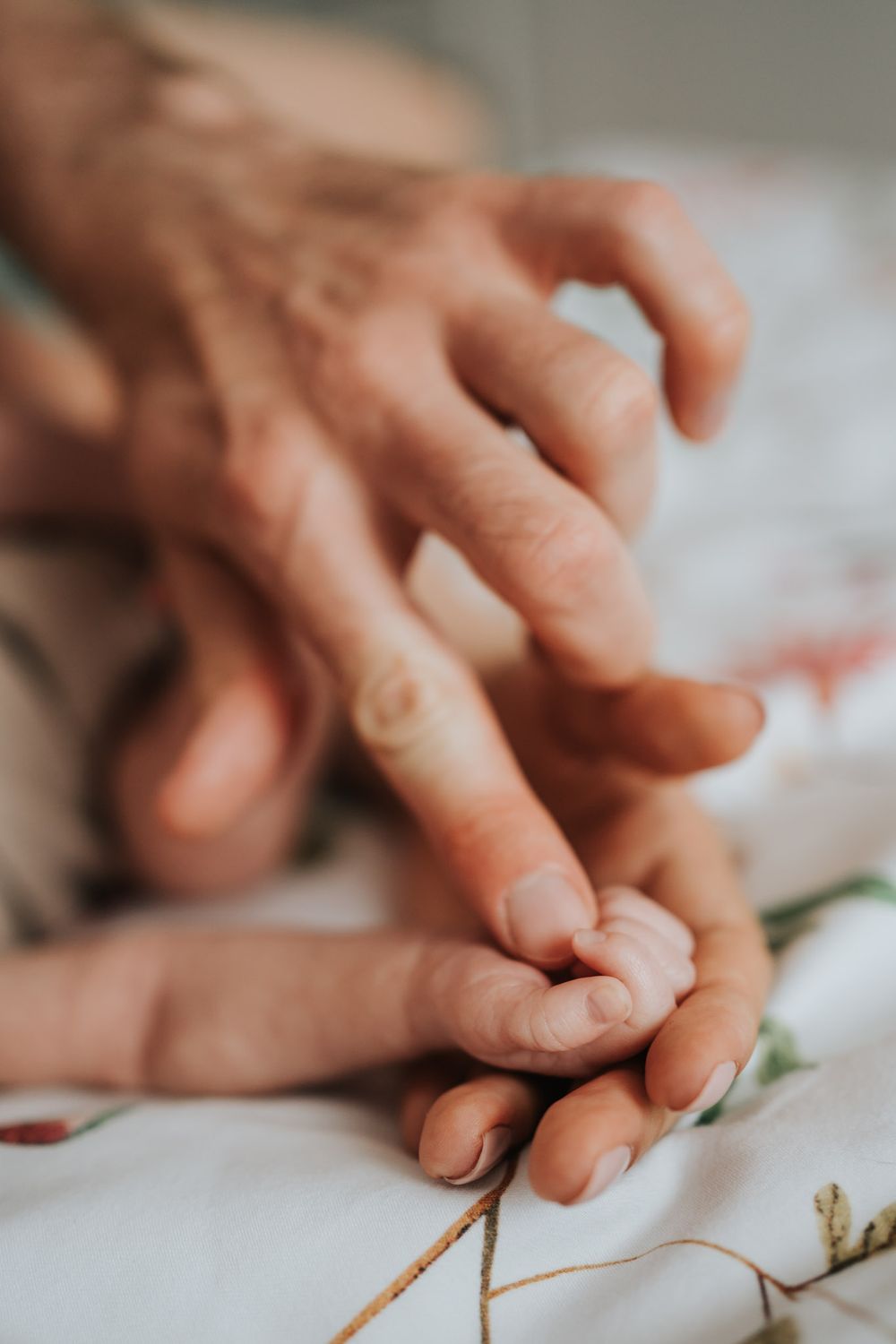 zbliżenie na rączkę córeczki, mamy i taty - sesja domowa Kraków