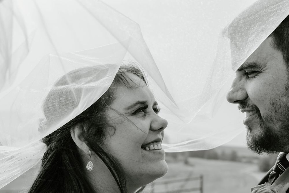 Bride and groom underneath veil, black and white artistic photo at Willow Hill Lodge