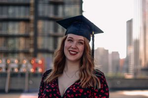 New graduate posing on a rooftop in downtown Calgary.