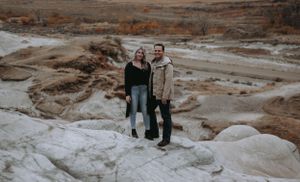 Couple standing on Drumheller hoodoos.