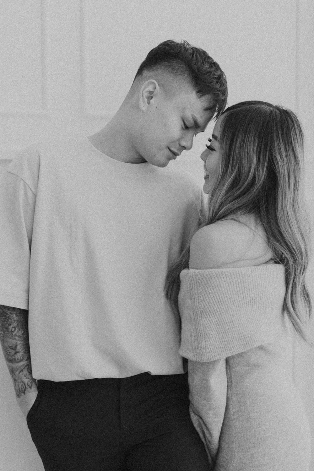 Black and white photo series showing a couple in light colored sweaters sharing tender moments.