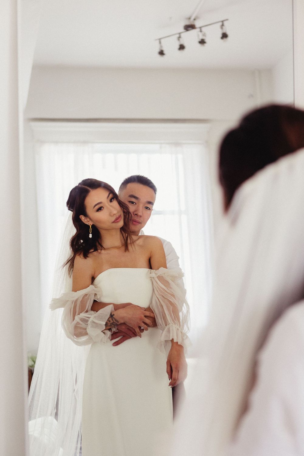 Intimate wedding photography session in a bright white studio space.