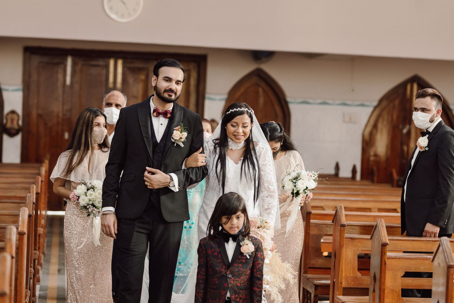 Church wedding ceremony with wooden pews and guests observing the proceedings.