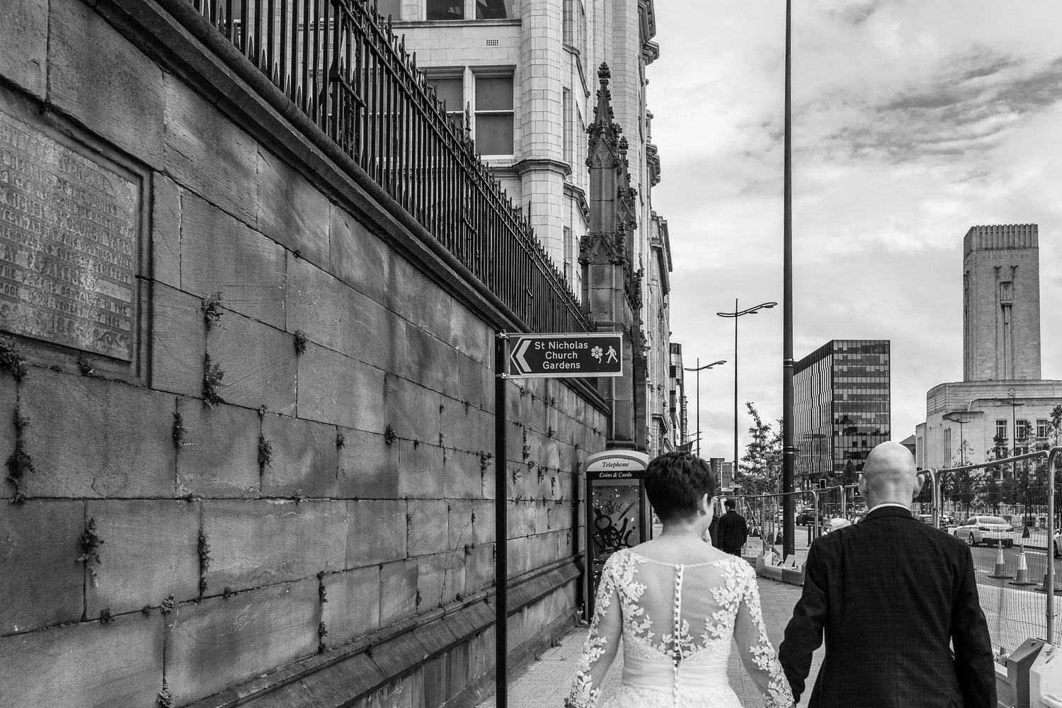 Bride and groom walk along the dock road towards St.Nicholas Gardens Liverpool city centre. Stuart Morris Photography