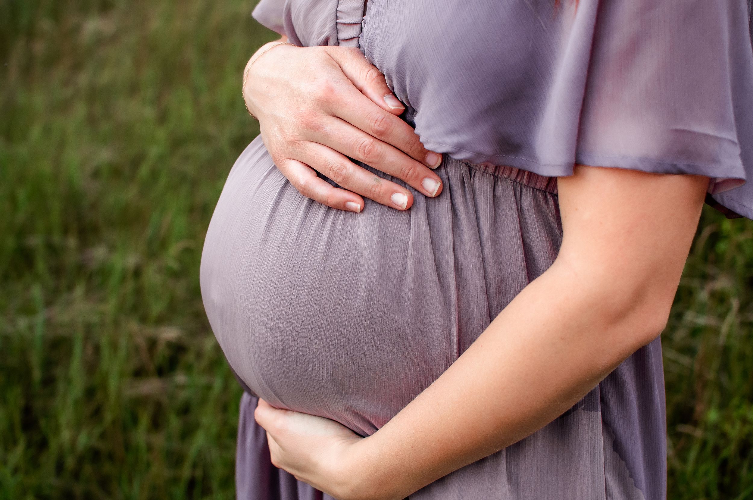 Mom embraces baby bump in a rural North Dakota maternity session - golden hour family photographer serving southwest North Dakota