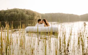 A romantic scene on a floating mattress surrounded by reeds in a serene lake.