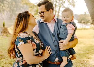 Loving family moment captured in golden hour lighting with matching dressy outfits.