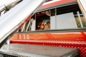 Couple seen through vintage truck window sharing romantic moment.