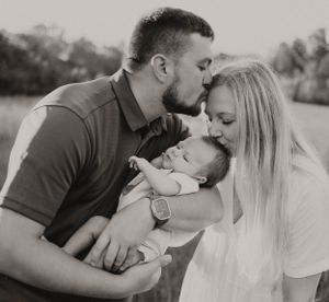 A tender family portrait in black and white featuring a small baby.