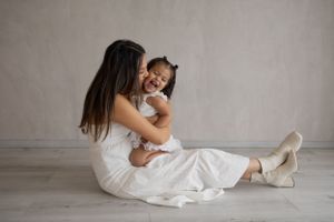 Artistic family portrait series showing intimate moments on light wood flooring.