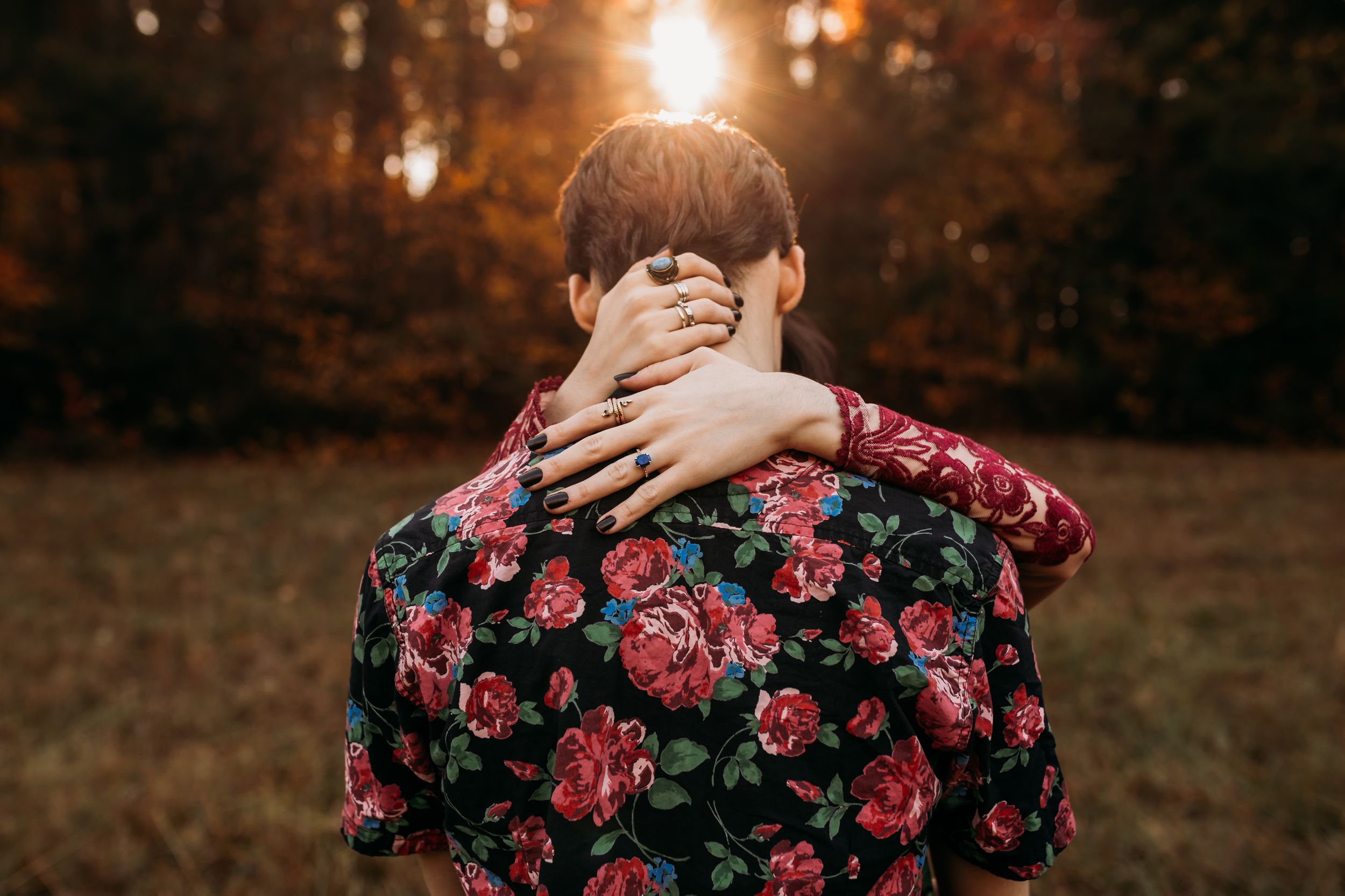 Photo of a couple in golden light showing the girls engagement ring.