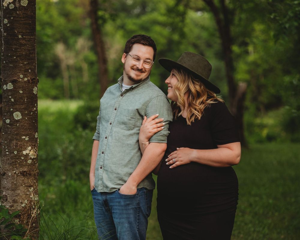 Candid family moment captured in wooded area with natural greenery backdrop.