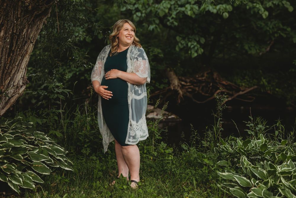 Outdoor family photography session in lush green forest setting during golden hour.
