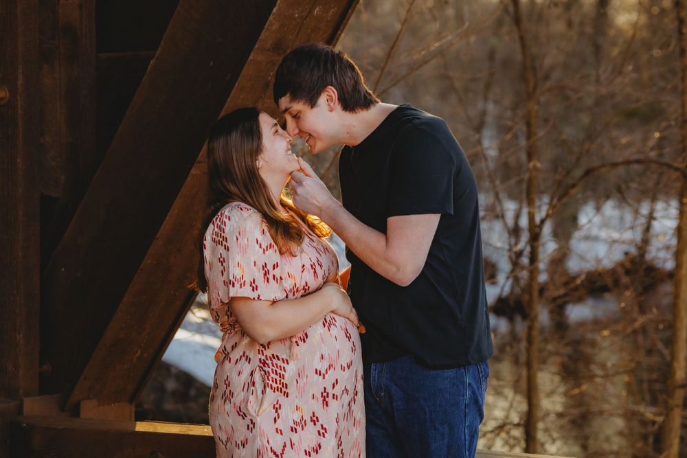 Romantic engagement photos captured in rustic barn setting with warm lighting.