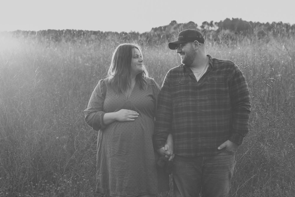 A romantic black and white photo session of a couple in a meadow.