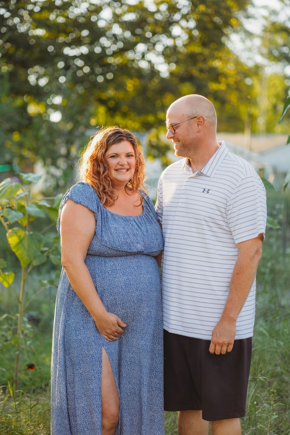 A couple shares an intimate moment in their garden during sunset.